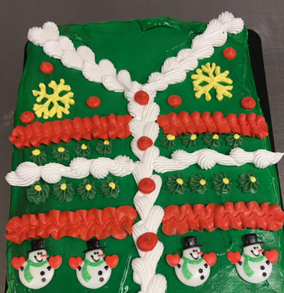 Rectangle Christmas sweater cake in green with white or red stripes and snowflake design.