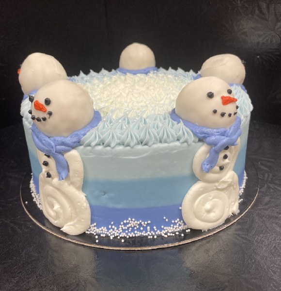 Round stacked cake in ombre blue colours with five snowmen on the sides.