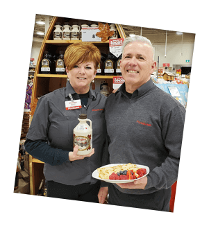 Steve & Joanne Strom of Elliot Lake hold their favourite holiday products in front of a stand in their Foodland store.