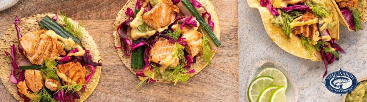 Overhead shot of crispy salmon tacos topped with fresh dill and red cabbage